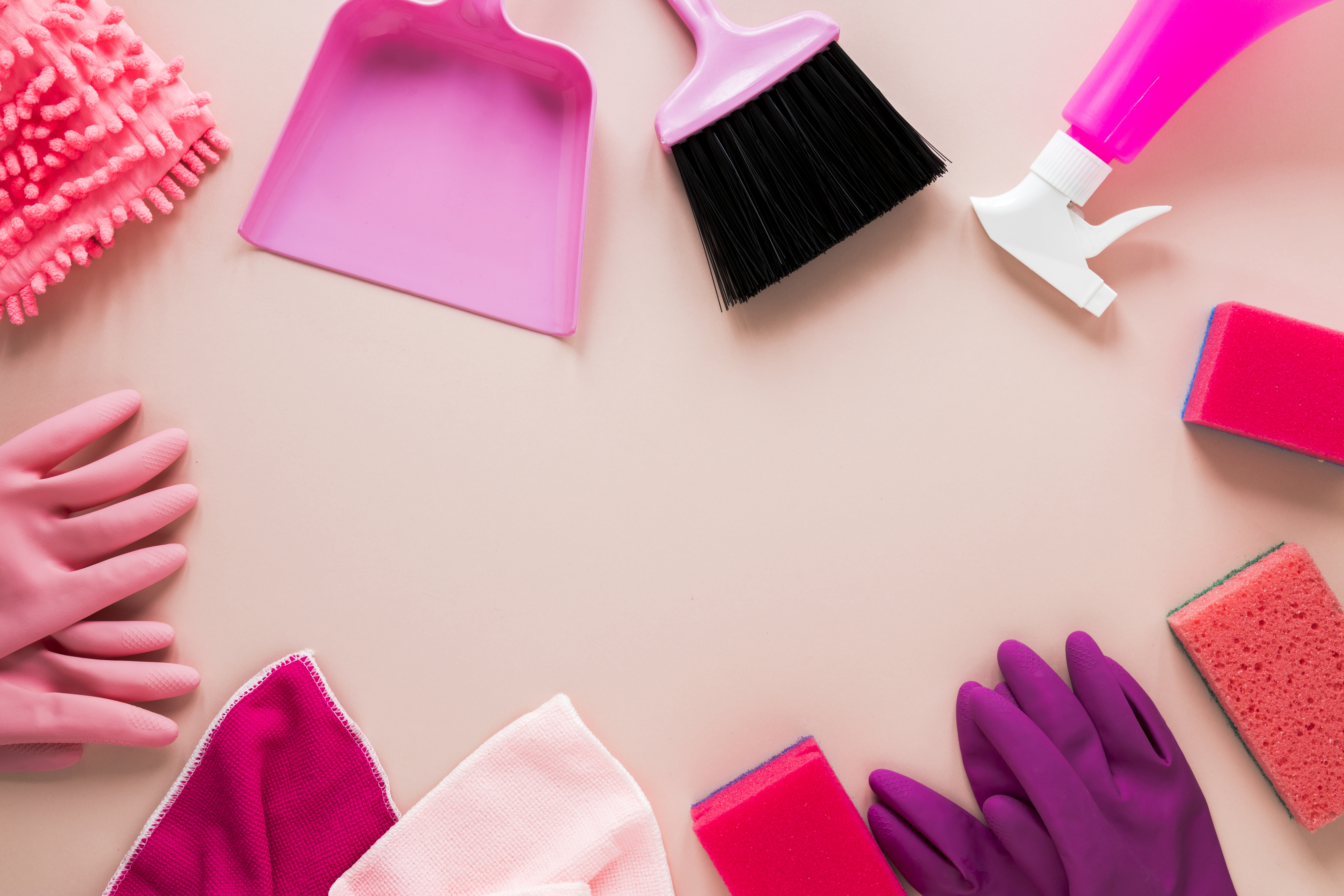 Pinkes Reinigungsequipment – Bürsten, Handschuhe, Schwämme und Sprühflasche auf rosa Hintergrund